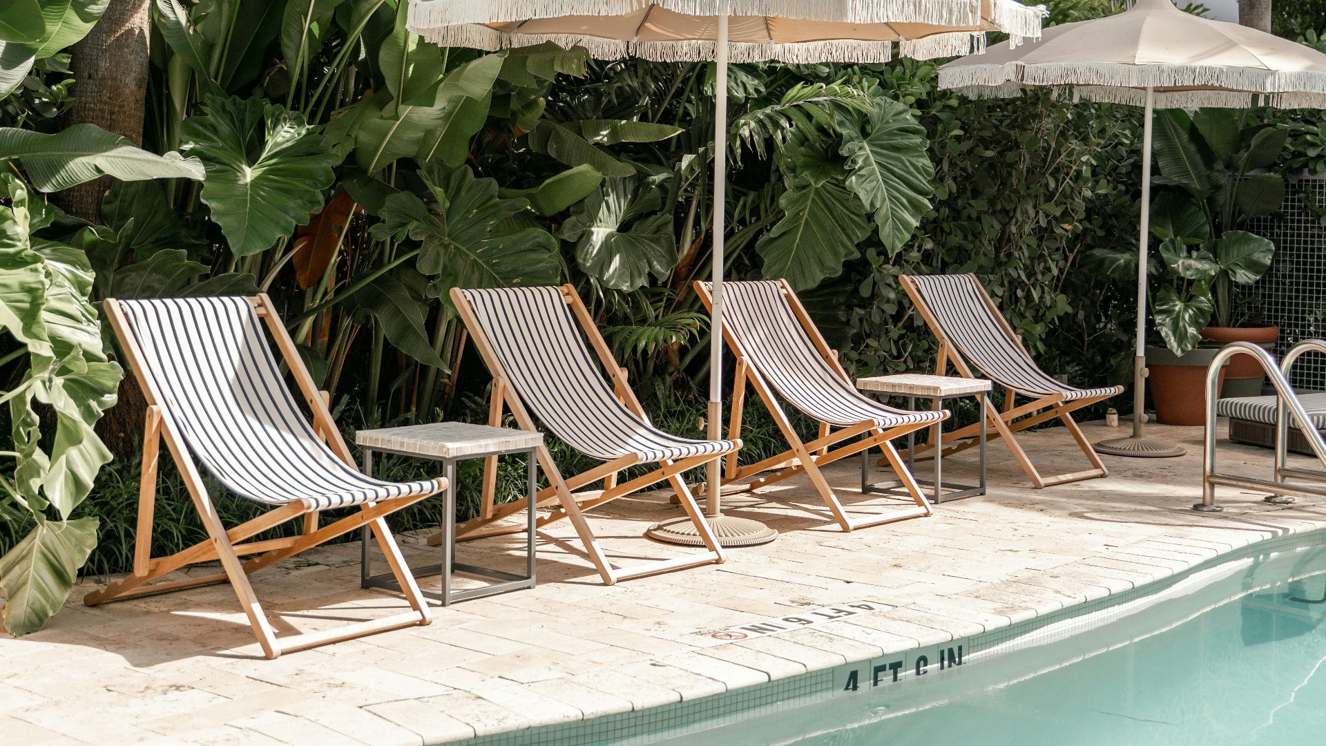 brown wooden folding chairs near swimming pool during daytime