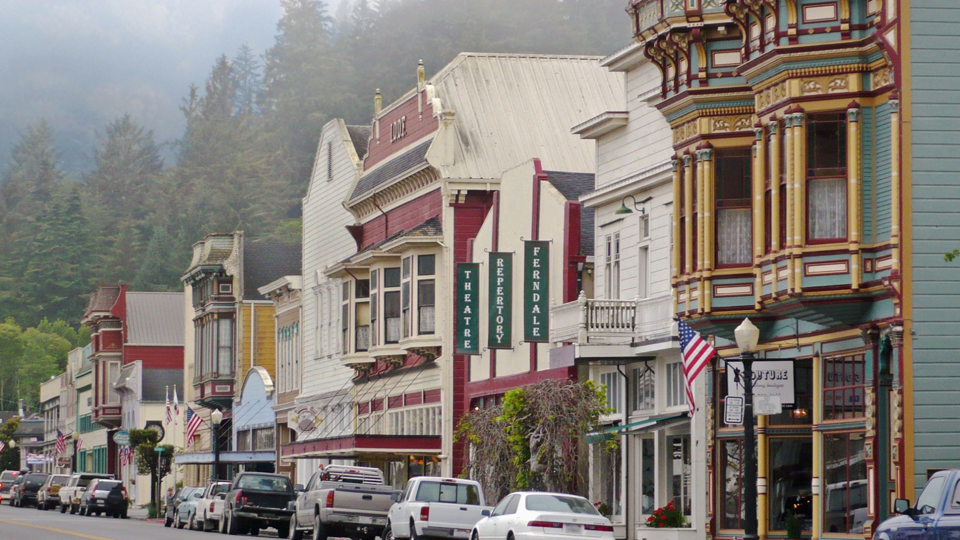 It shows the well-preserved Victorian architecture in the Main Street Historic District in Ferndale, California.
First visible polychrome building with flag is 475 Main Street, then 455 Main, and the Ferndale Repertory Theater at 441-451 Main.  This image