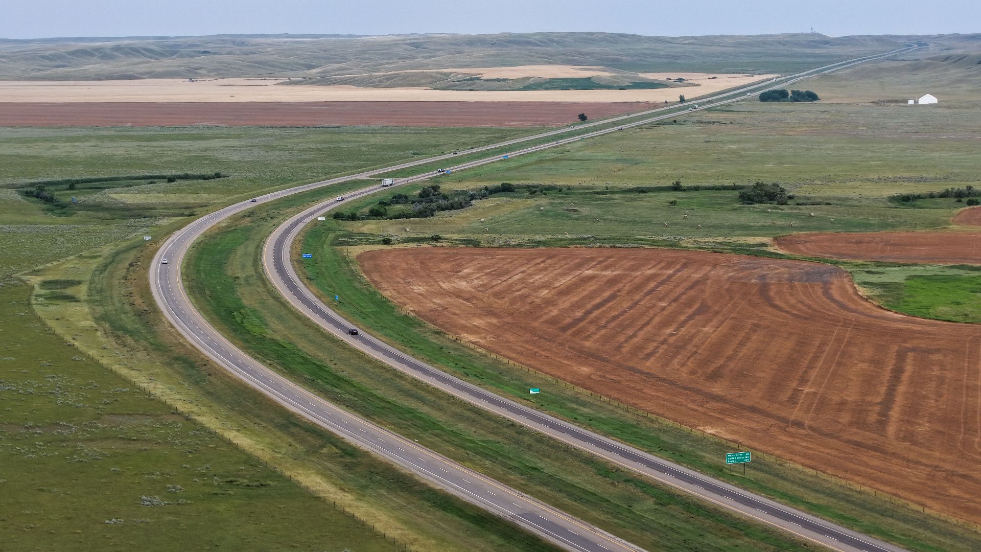 Aerial view of Saskatchewan Highway 1, part of the Trans-Canada Highway, just east of the Alberta boundary near Walsh, crossing the rolling prairie of the Maple Creek Plain.