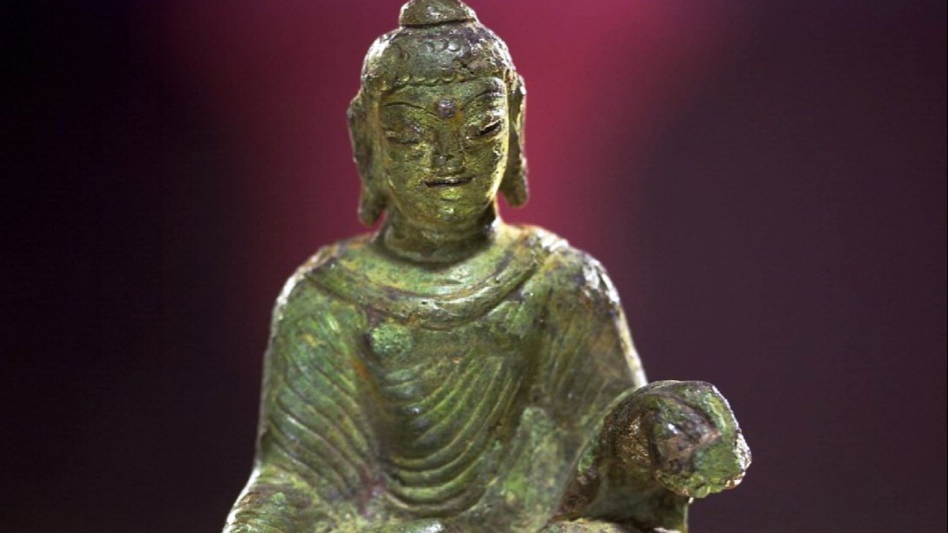 Buddhastatyetten har tillverkats i Swatdalen i Indien på 500-talet och förts till Helgö på Ekerö under vikingatiden. Statyetten är 8,4 centimeter hög.