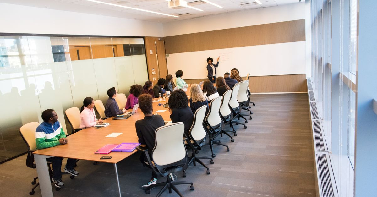 A diverse group actively collaborating in a bright, modern conference room setting.