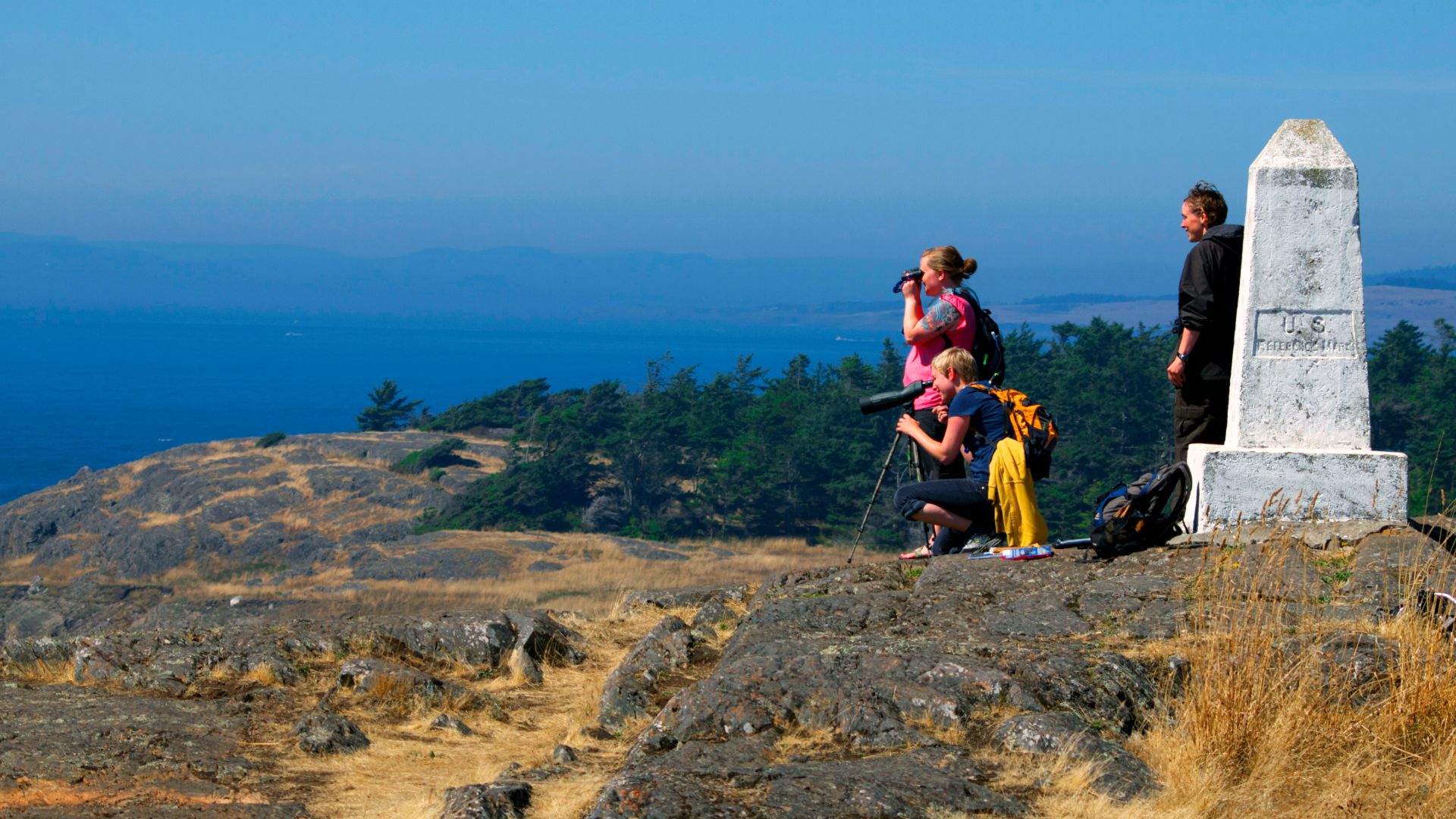 Tourists at the Iceberg Point Reference Mark on Lopez Island, Washington