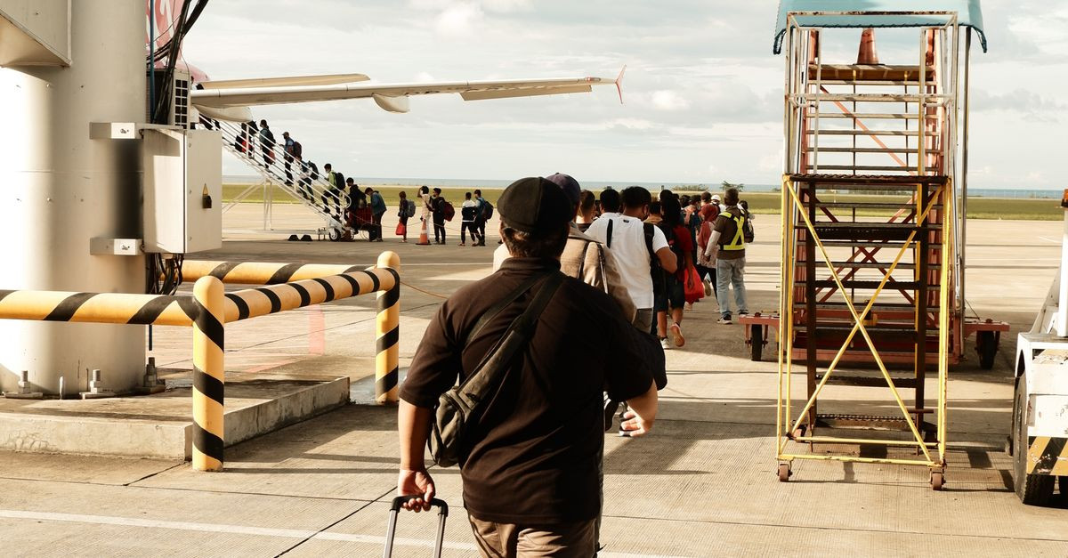 A man with luggage boarding a plane at Laguindingan Airport in the Philippines.