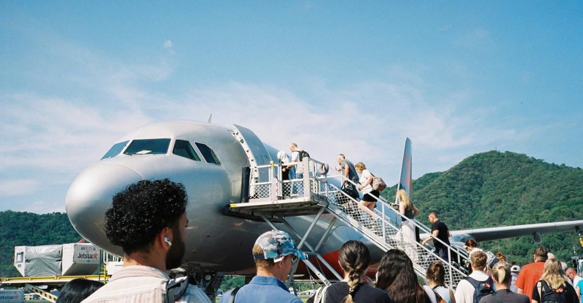 A group of people standing around a plane