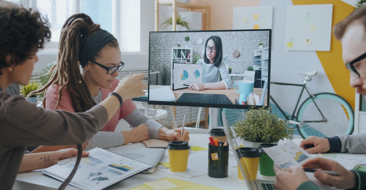 Young professionals collaborate during a video call in a creative and modern office setting.