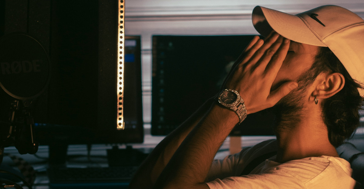 a man sitting in a chair with his head in his hands