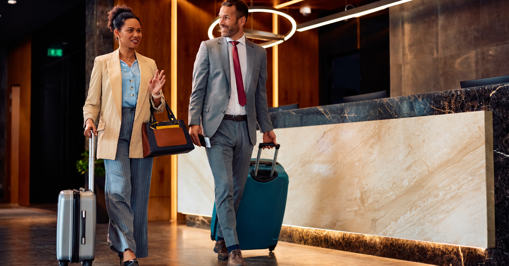 Happy African American businesswoman talking to her colleague while arriving at the hotel.