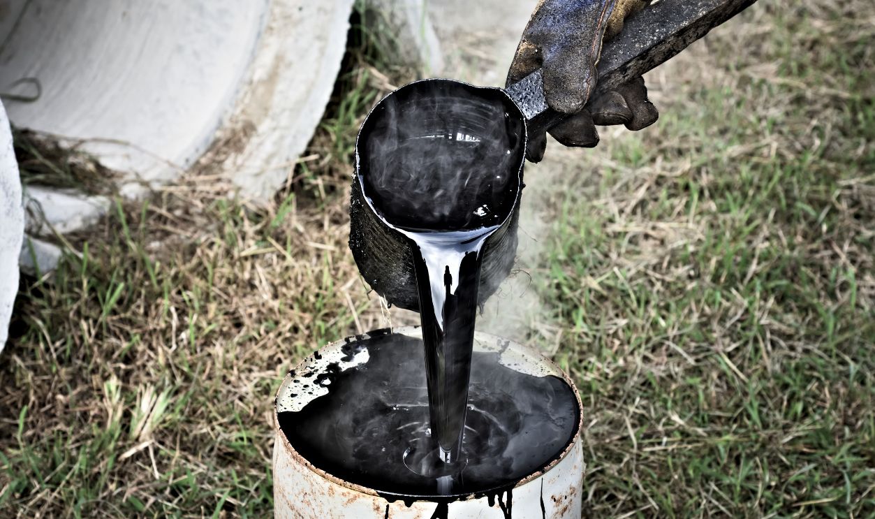 Shutterstock - 1156202281 - A man working with hot tar.