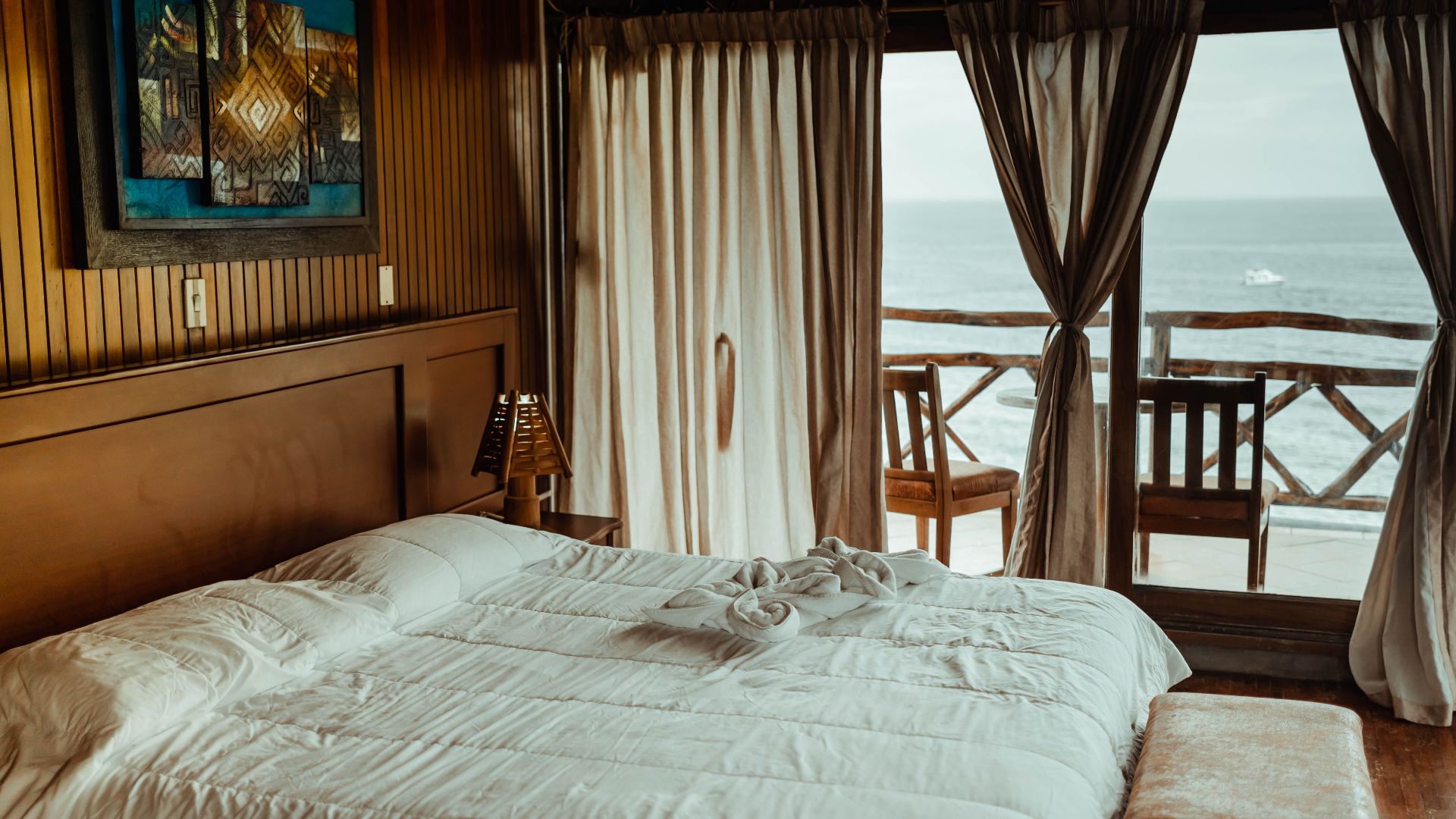 Luxurious seaside bedroom featuring a plush bed, elegant decor, and stunning ocean view for a serene escape.