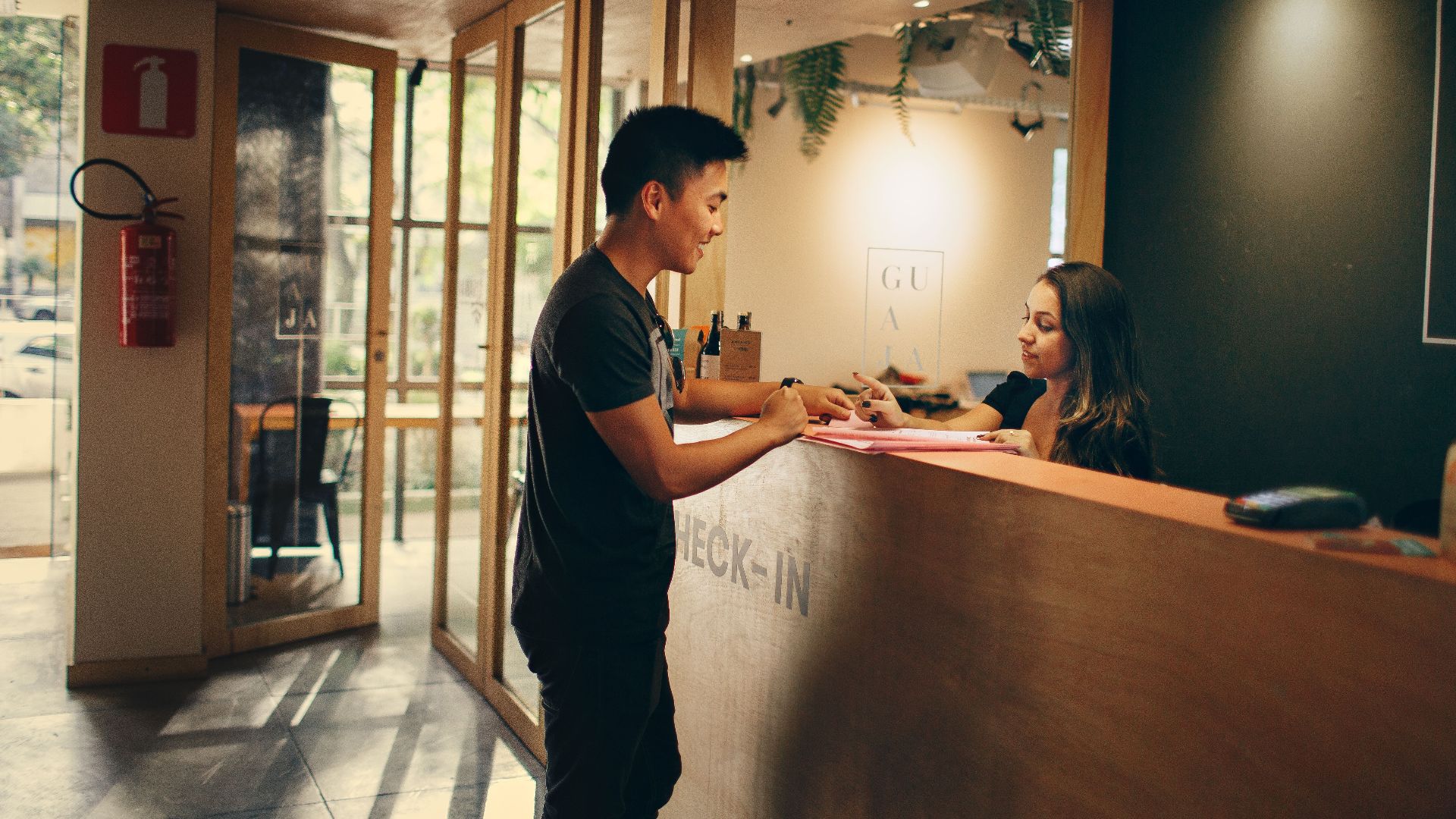 A customer checks in at a hotel reception desk in Belo Horizonte, Brazil.