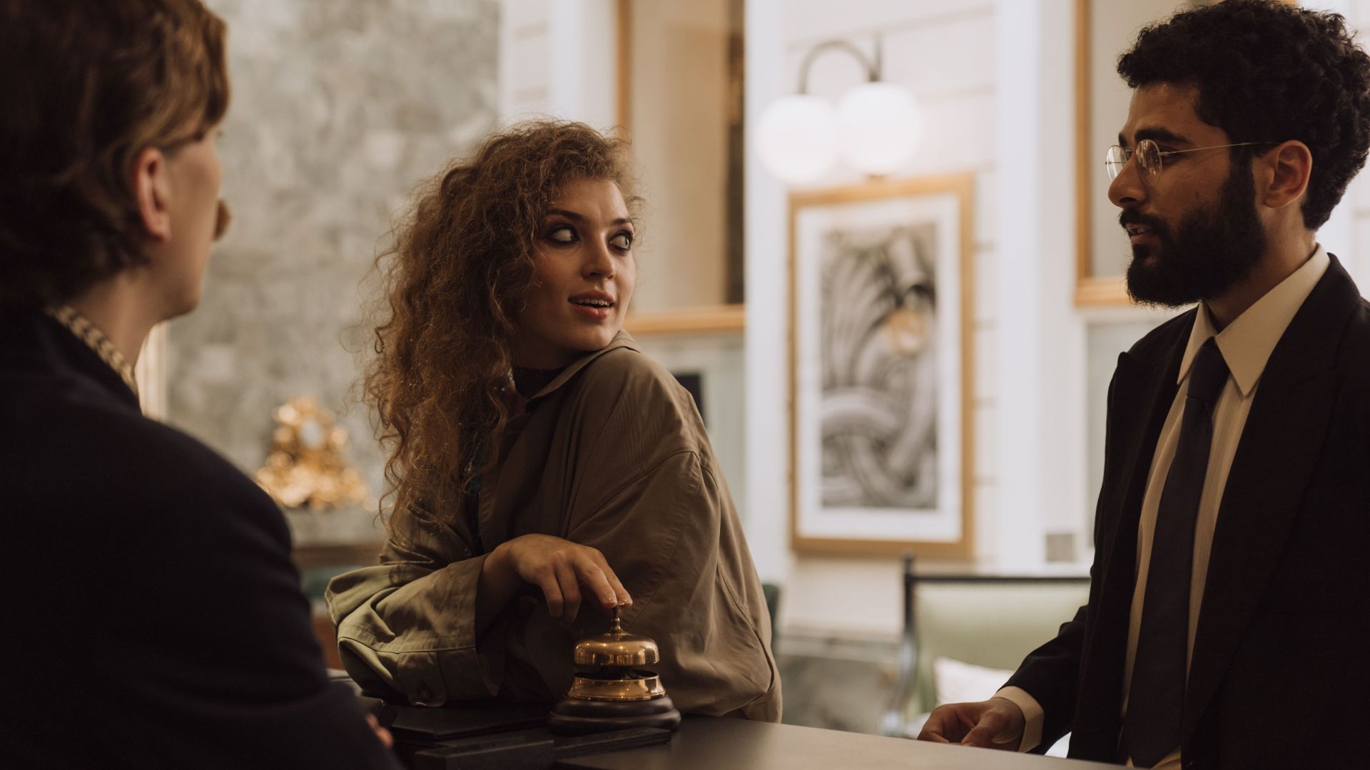 Guests interacting at a luxurious hotel reception desk, emphasizing hospitality and service.