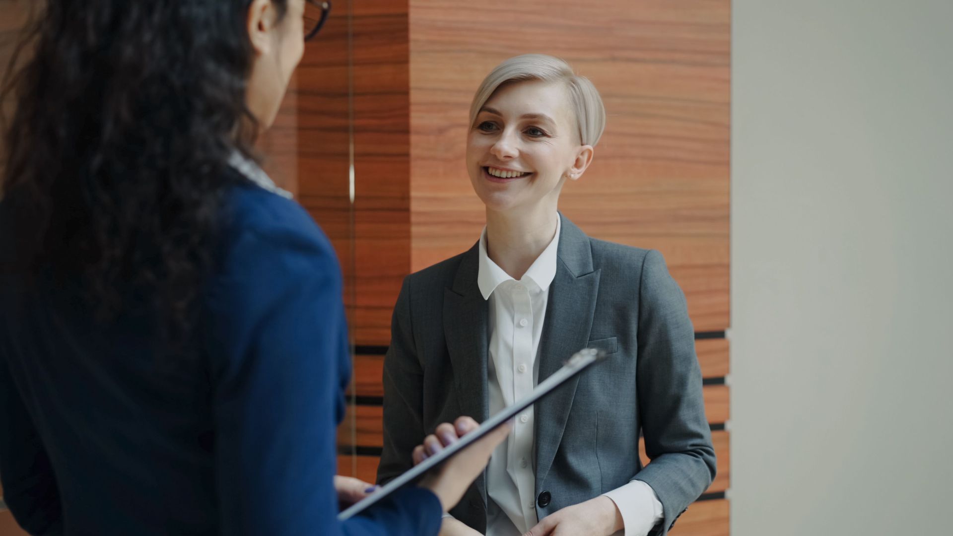 Two professionals having a conversation during a business meeting indoors.