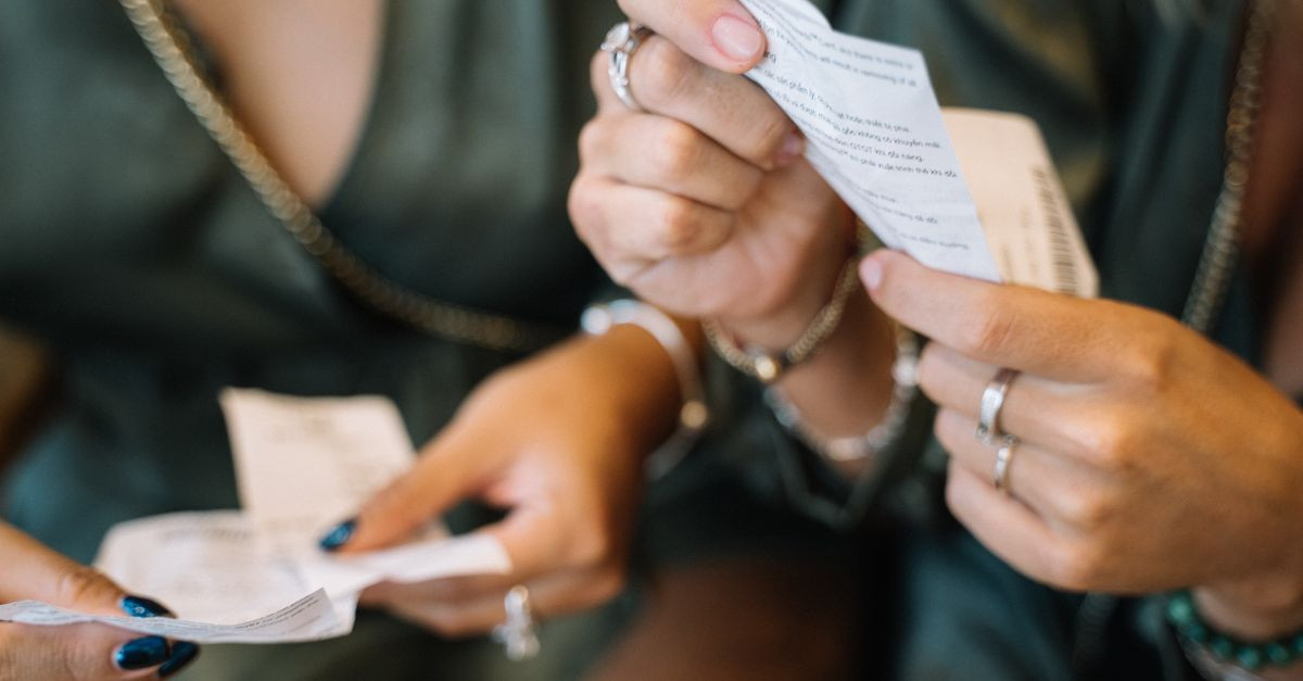 Two individuals reviewing receipts in a close-up scene, focusing on payment details.