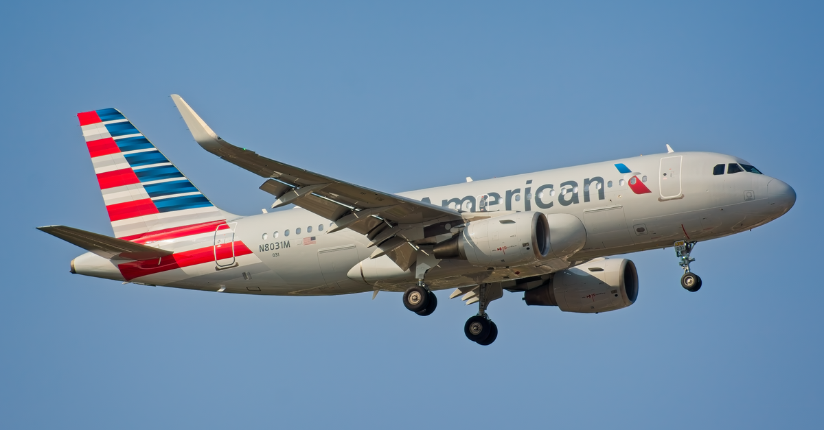 American Airlines Airbus A319 airplane landing under clear sky in New York City.