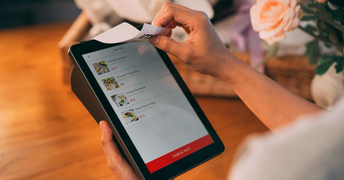 Hands using tablet for cashless payment, showcasing modern technology in retail.