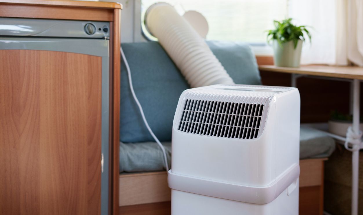 Portable air conditioner unit operating inside a modern camper van during a summer heatwave