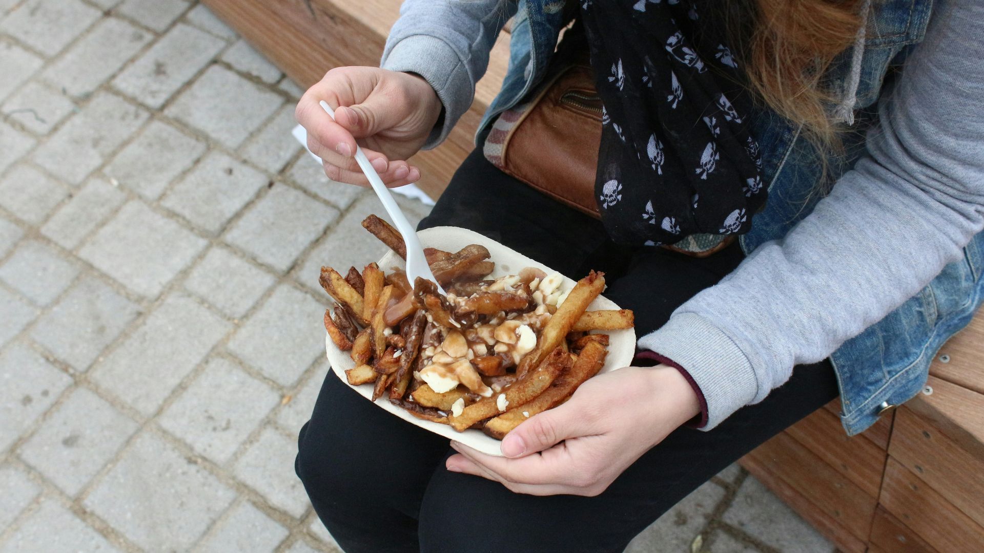person holding burger with fries