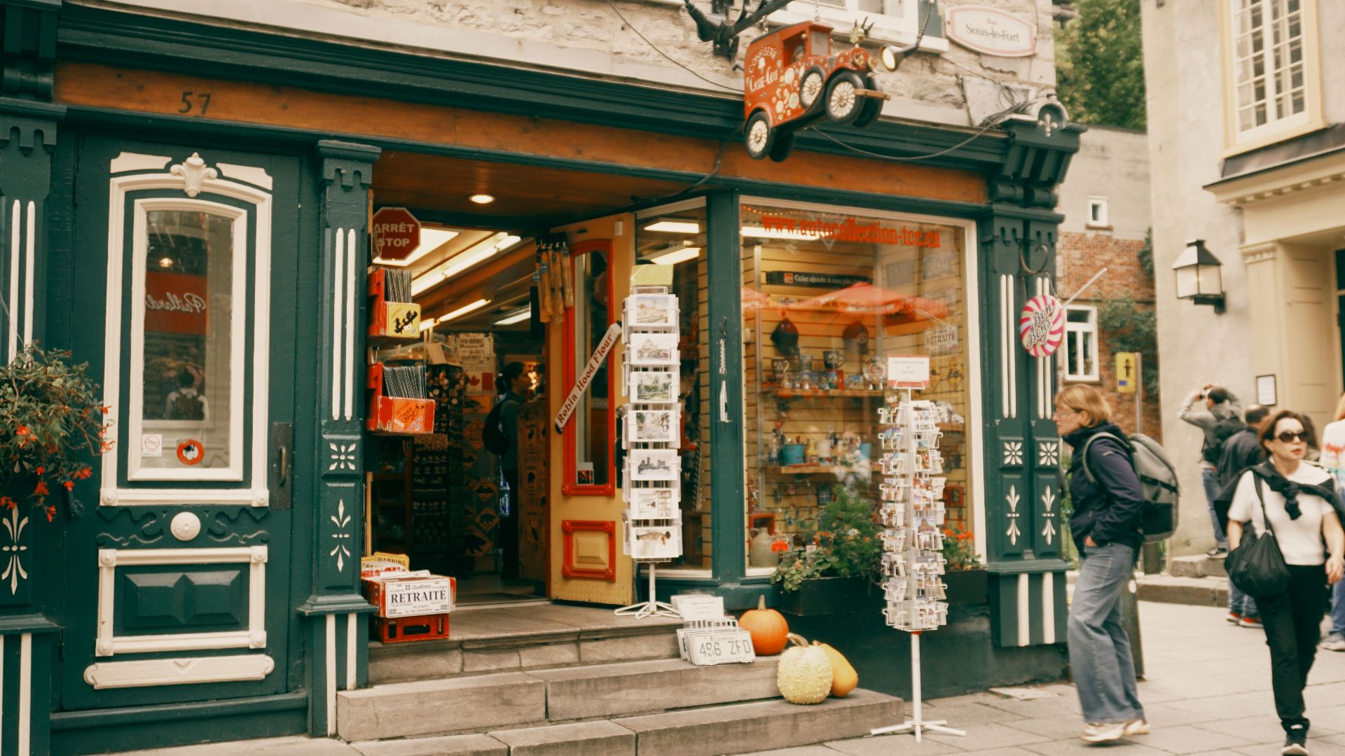 Vintage shop exterior on a quaint street in Old Quebec City, Canada, with people passing by.