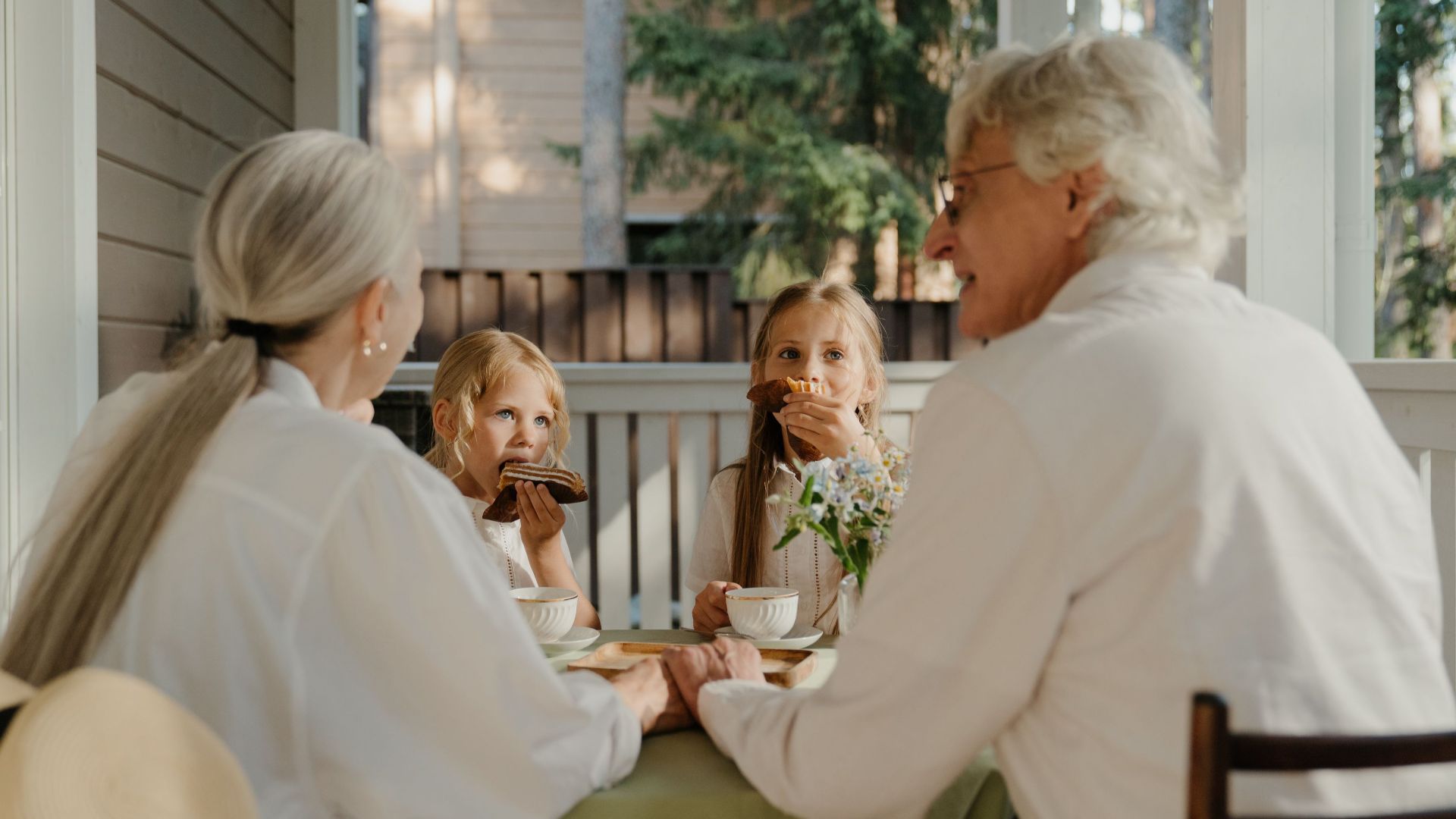 Grandparents enjoying quality time with their grandchildren at a patio table.
