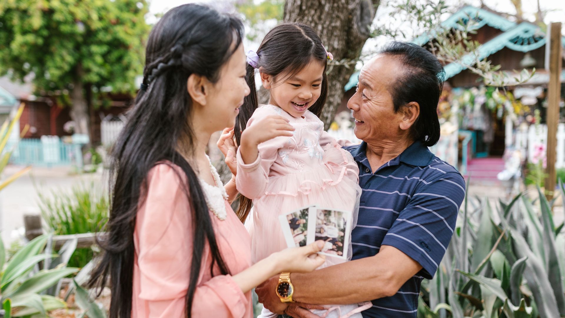 A joyful family scene with grandparents and child bonding outside.