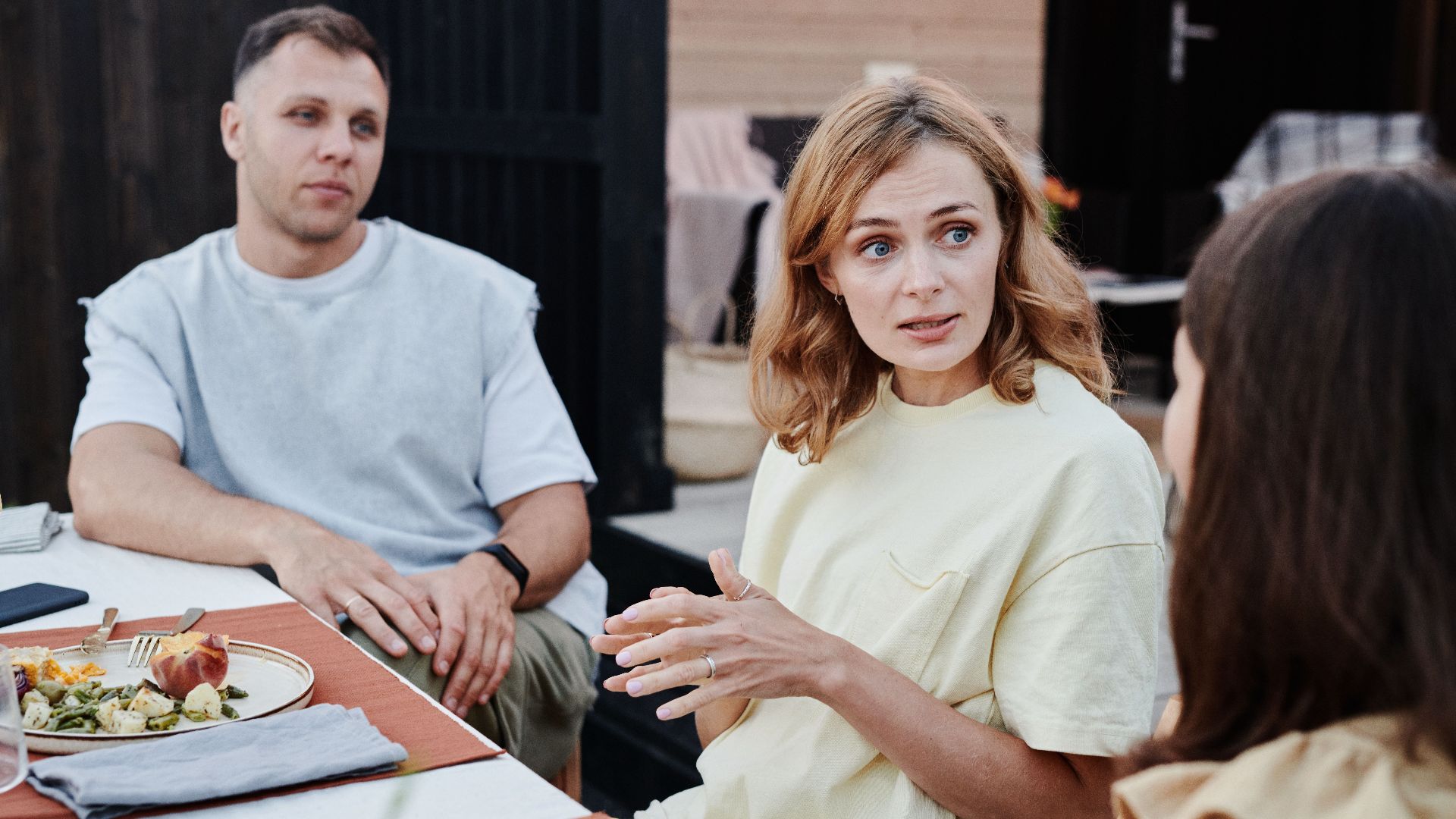 A group of adults enjoying a relaxed outdoor meal together.