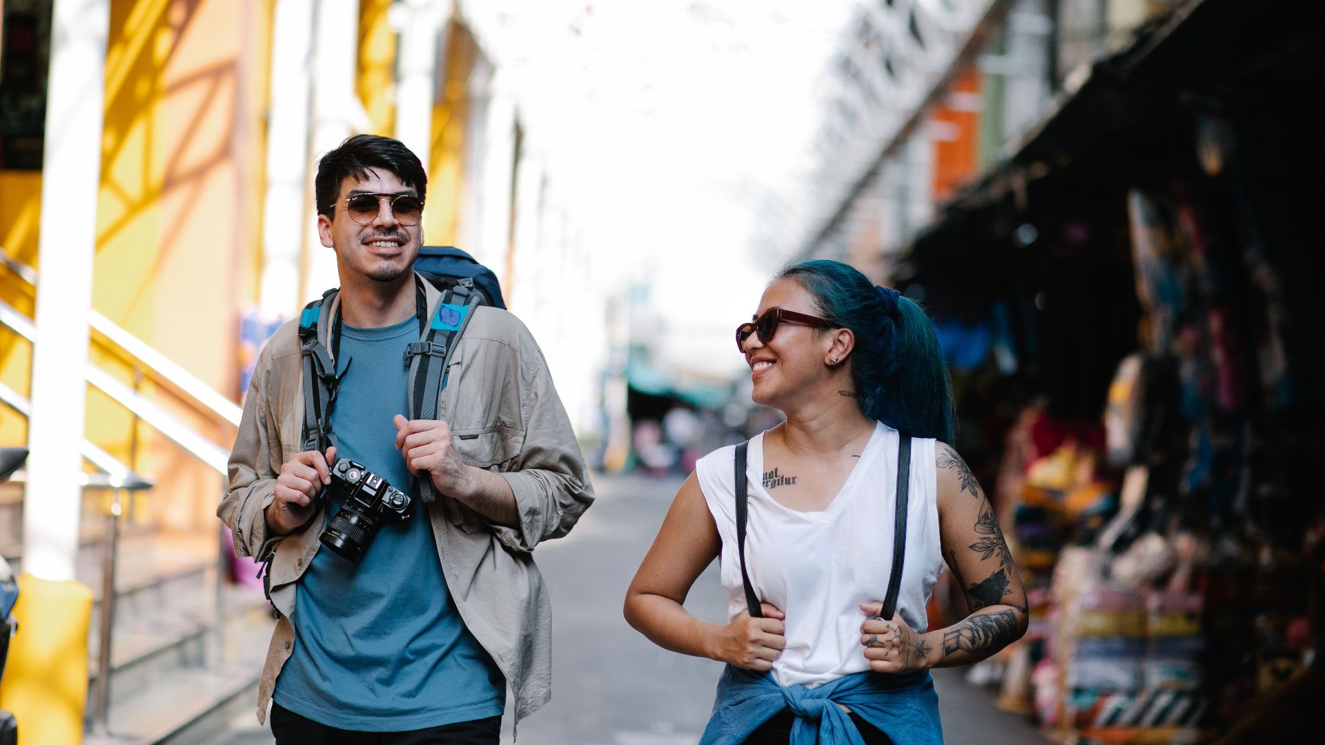 A cheerful couple with backpacks enjoying sightseeing during their travel adventure.