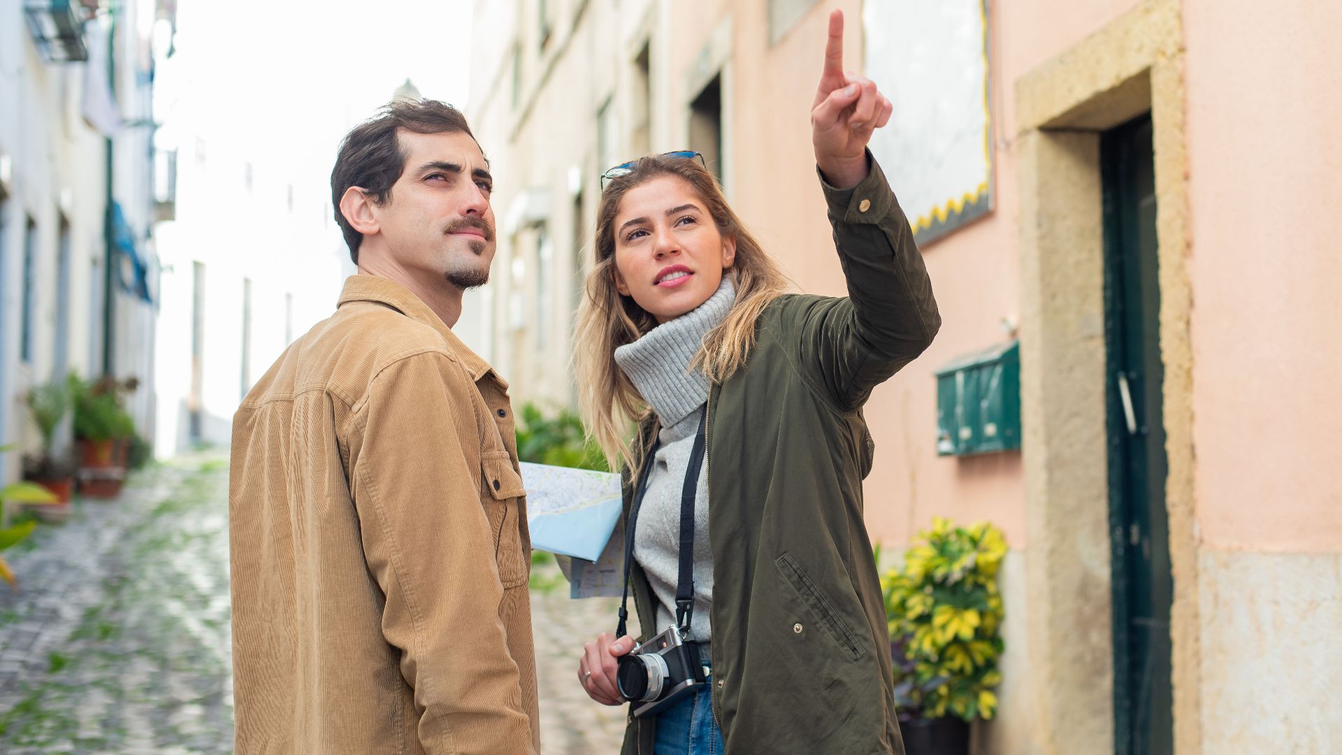 Young couple navigating a European street with a map, showcasing travel adventure.