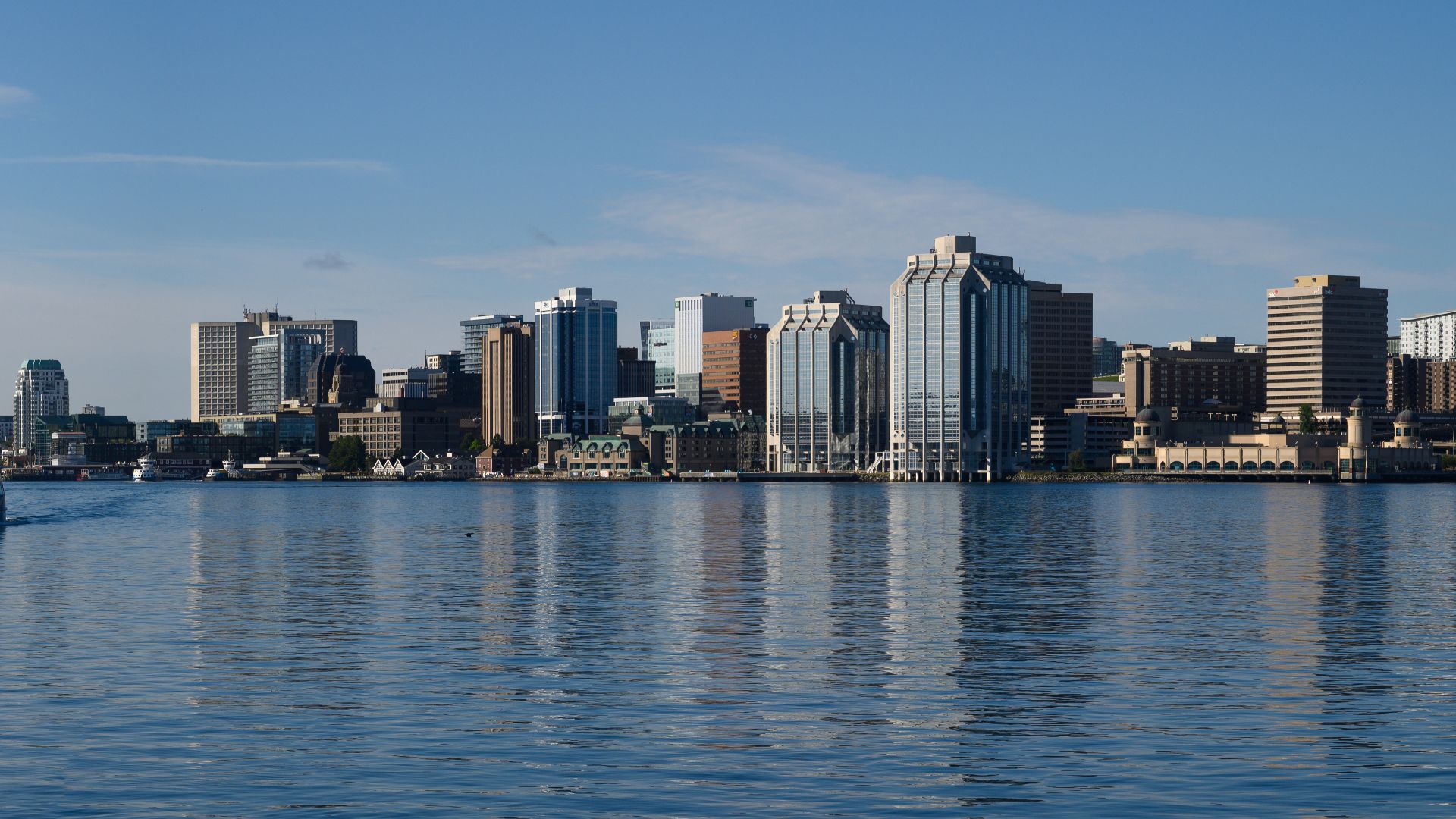 View of downtown skyline at Halifax, Nova Scotia, Canada on July 21, 2022. Halifax Transit ferry, VINCENT COLEMAN - IMO 9850317, at left, is heading towards Dartmouth Alderney terminal.