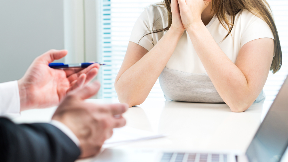 Young woman getting fired from work in office