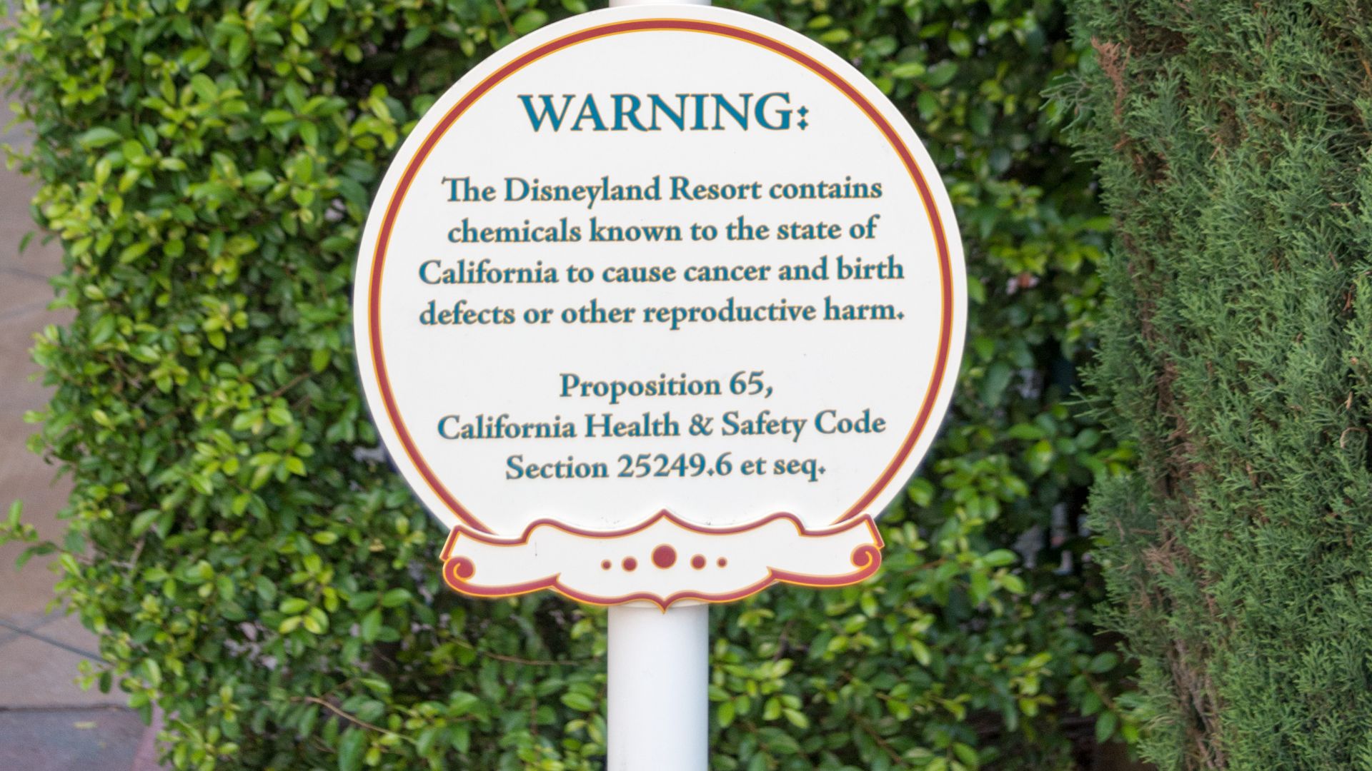 A Prop 65 warning sign at the picnic area next to the tram area at Disneyland Resort.
