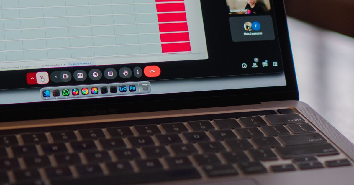 Laptop displaying a remote video meeting in a modern office setting.