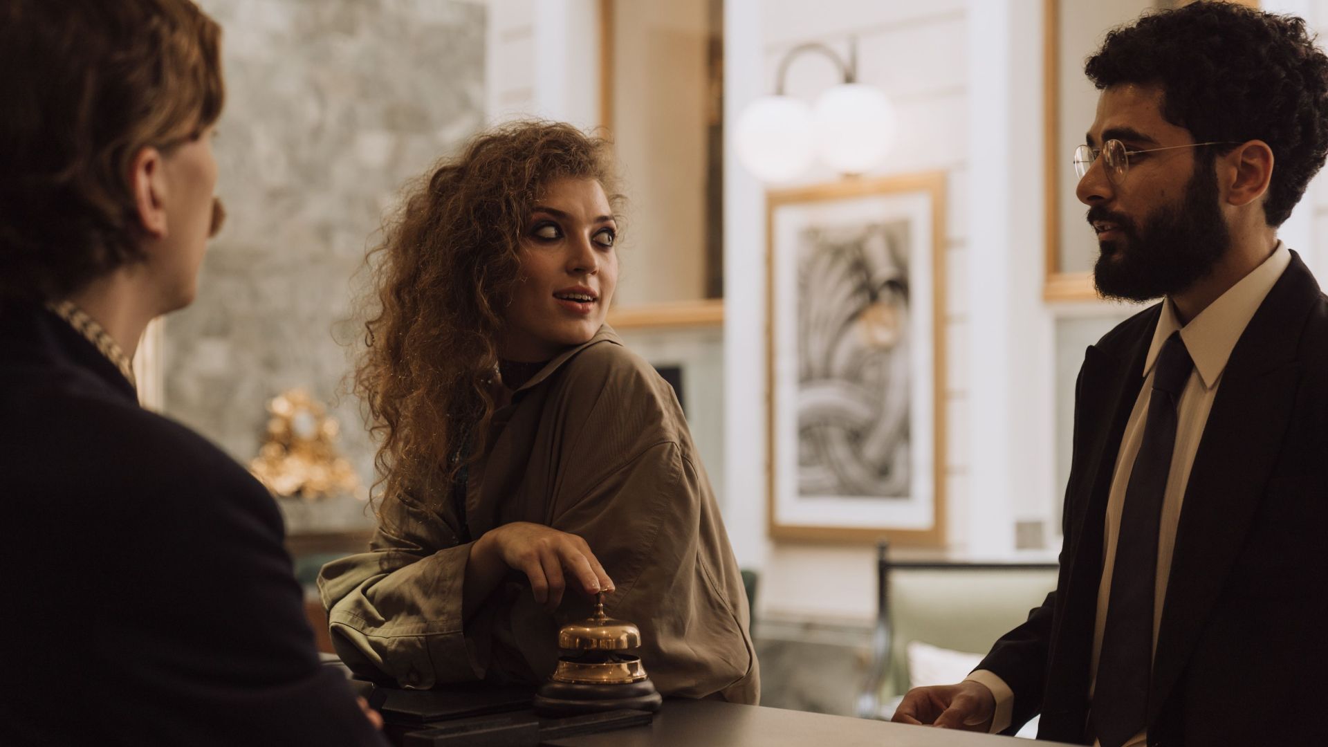 Guests interacting at a luxurious hotel reception desk, emphasizing hospitality and service.