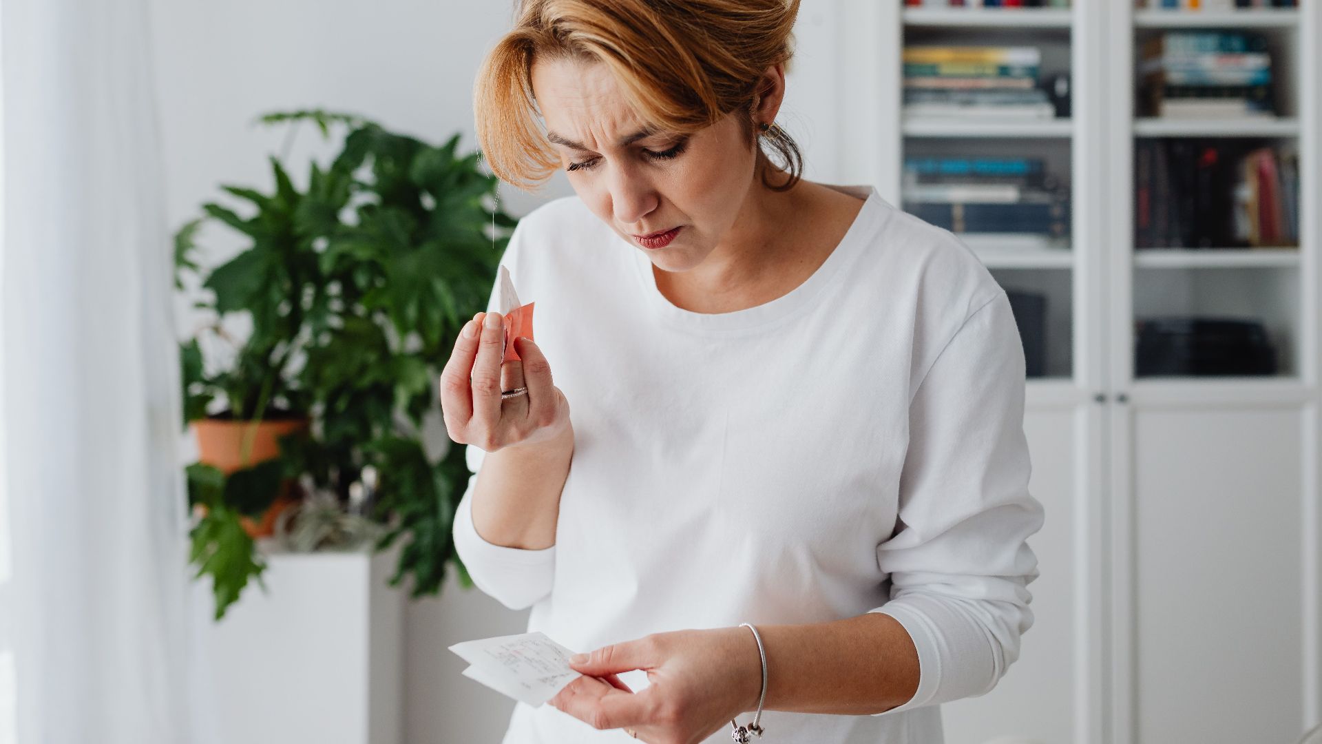 A concerned woman checks her bills, reflecting financial anxiety and budgeting challenges.