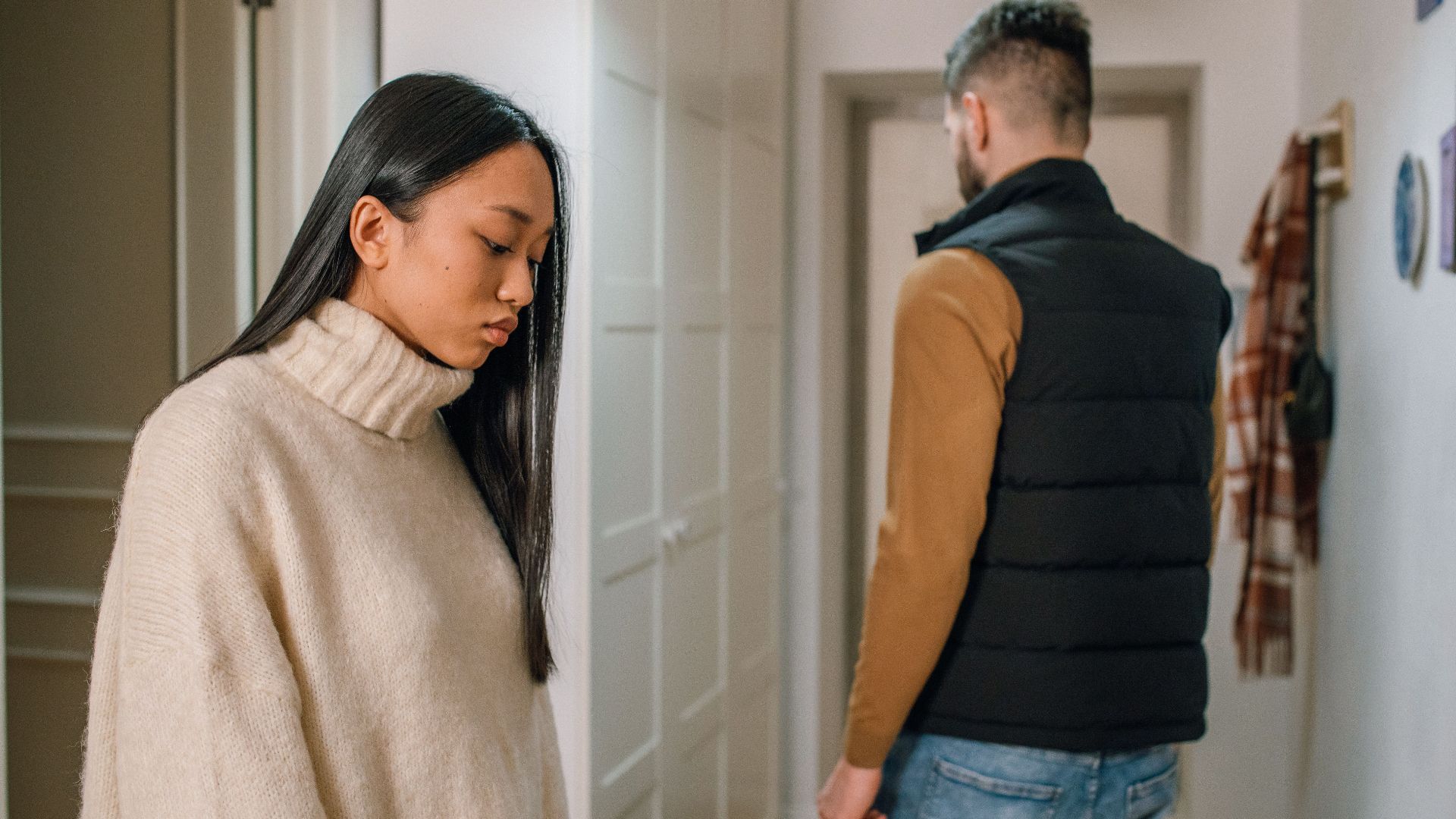 A couple experiencing relationship issues in a hallway, conveying emotional tension.