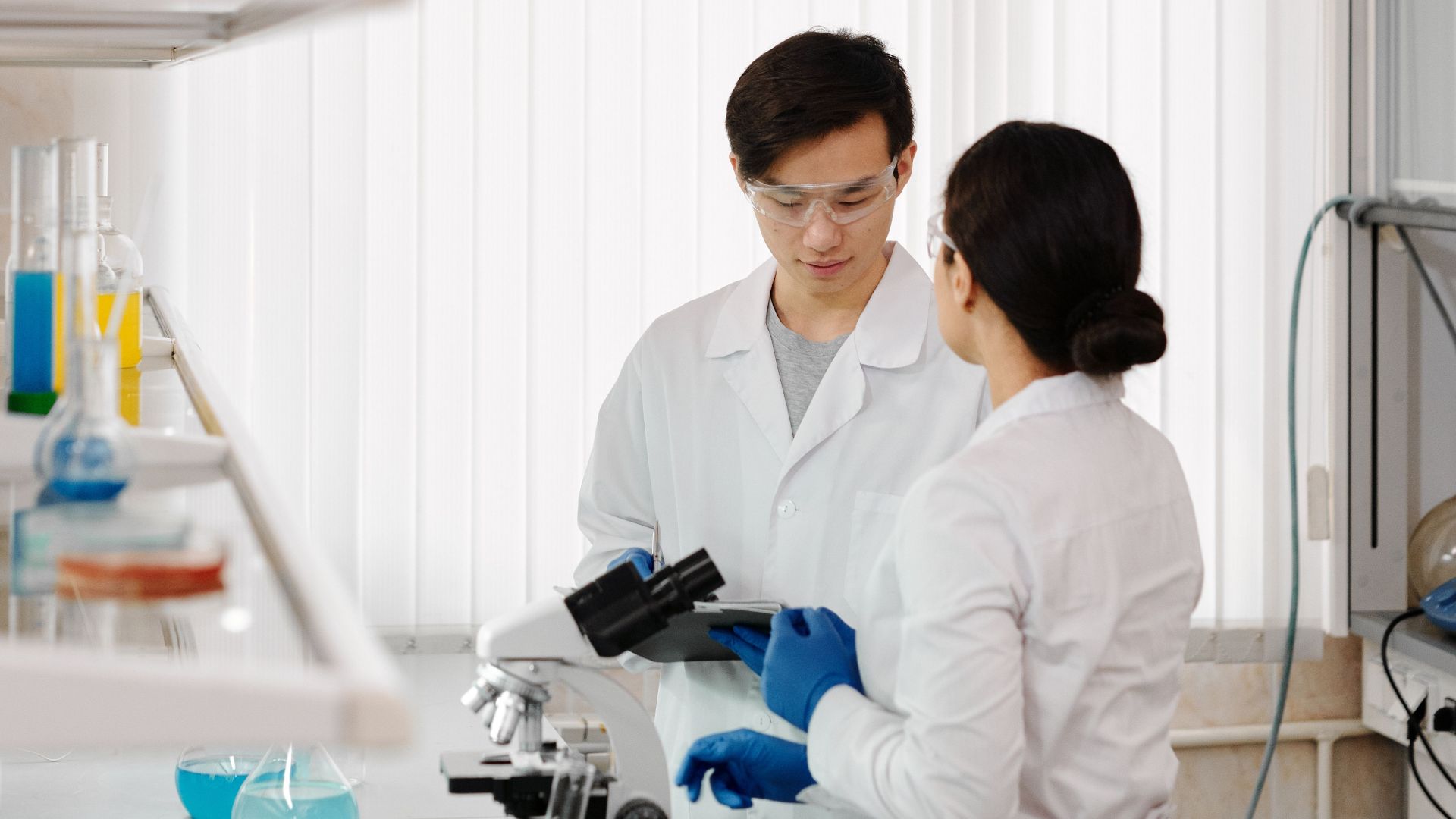 Two scientists in lab coats working in a sophisticated laboratory setting.