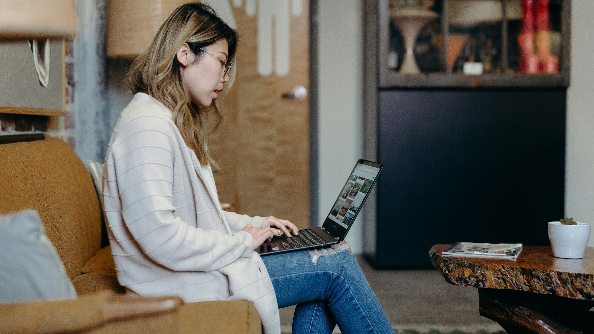 woman using laptop while sitting on sofa chair
