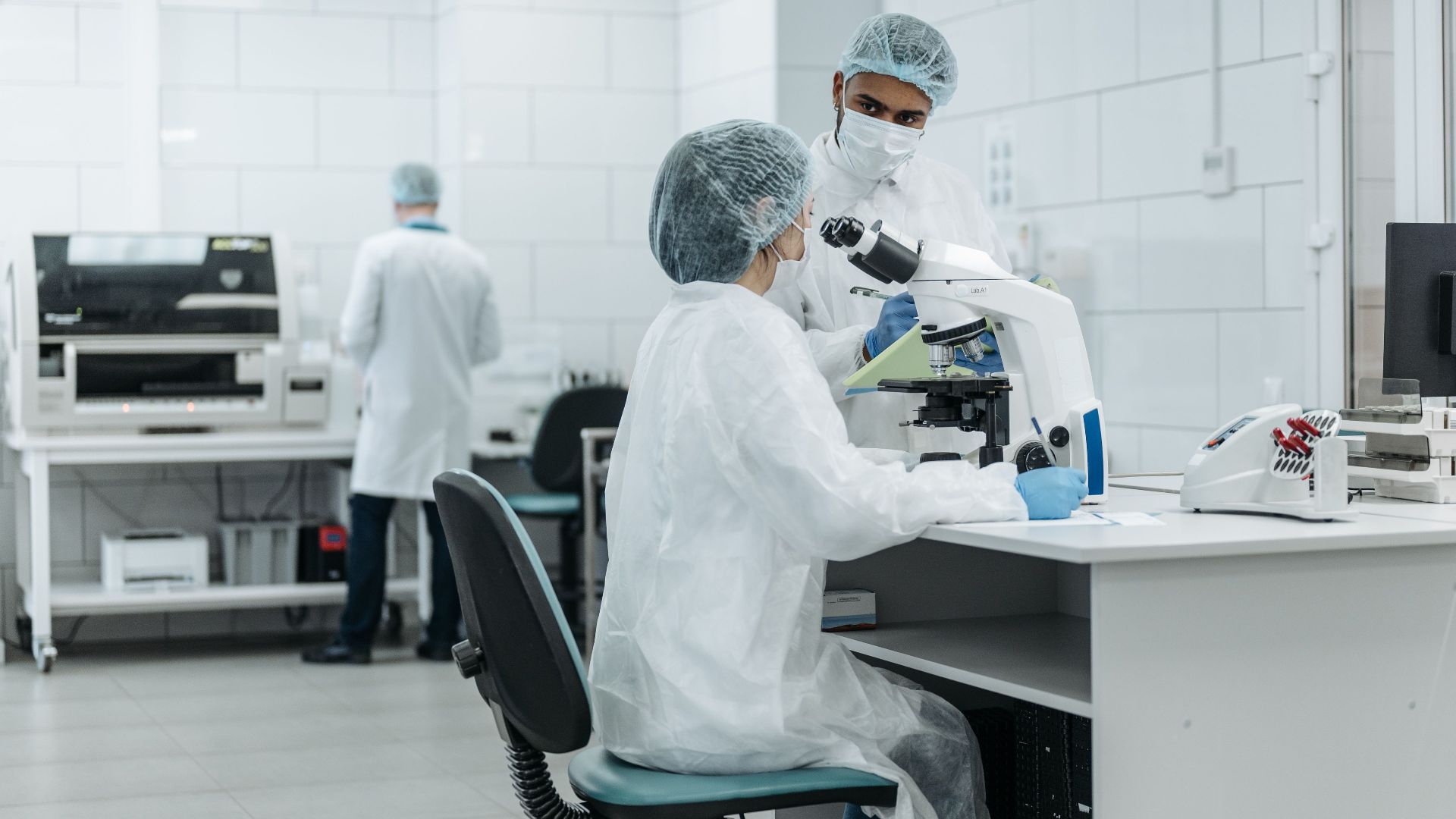 Laboratory scientists conduct research using advanced microscopes in a well-equipped lab.