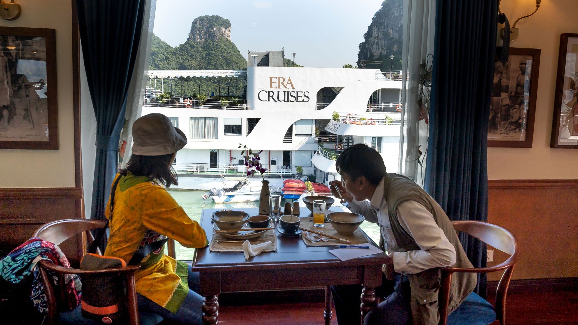 Side view of ethnic male tourist eating soup against unrecognizable female beloved at table on motorboat during cruise