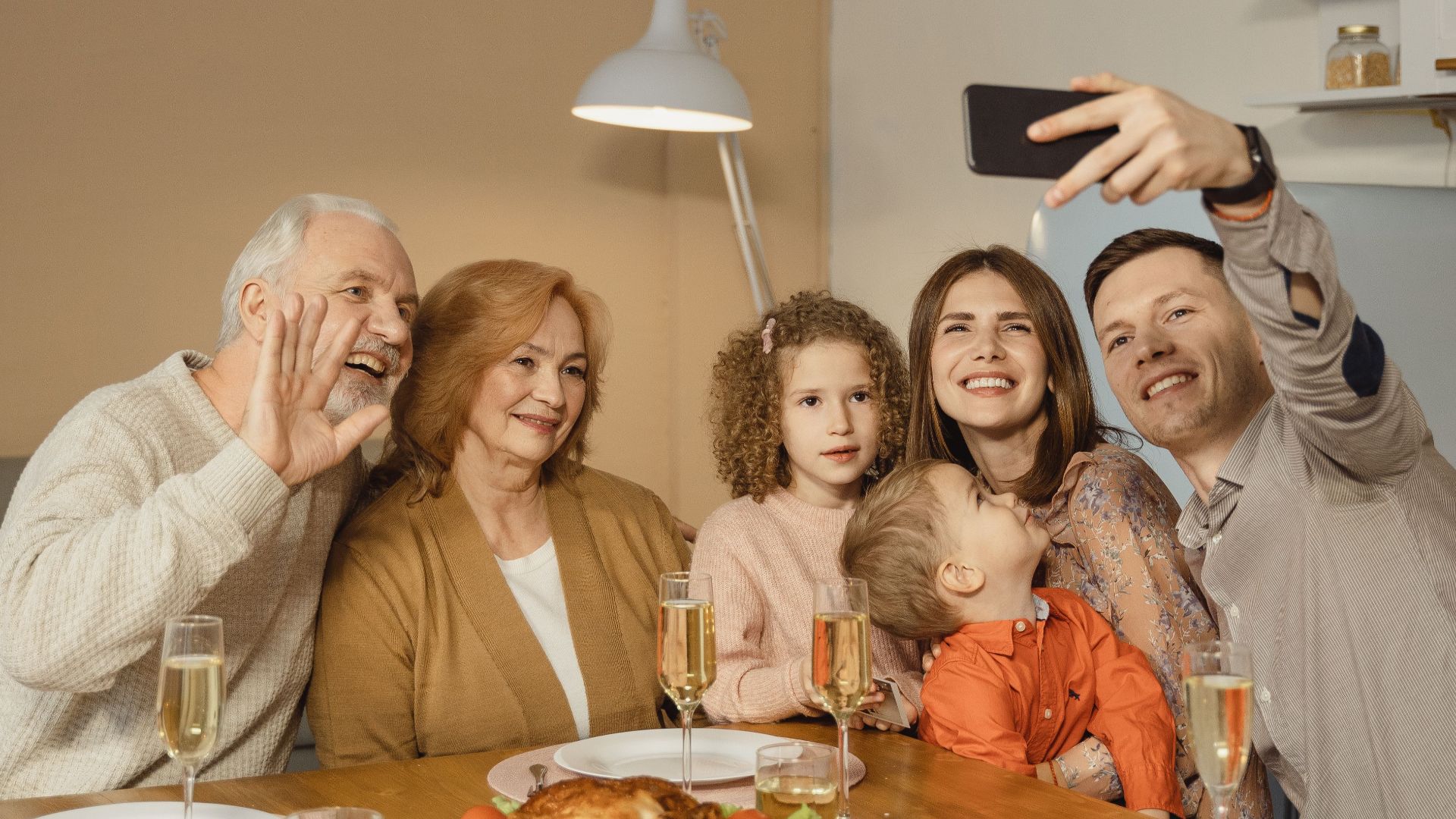 Happy family taking a selfie during a festive dinner gathering at home, capturing joyful moments together.