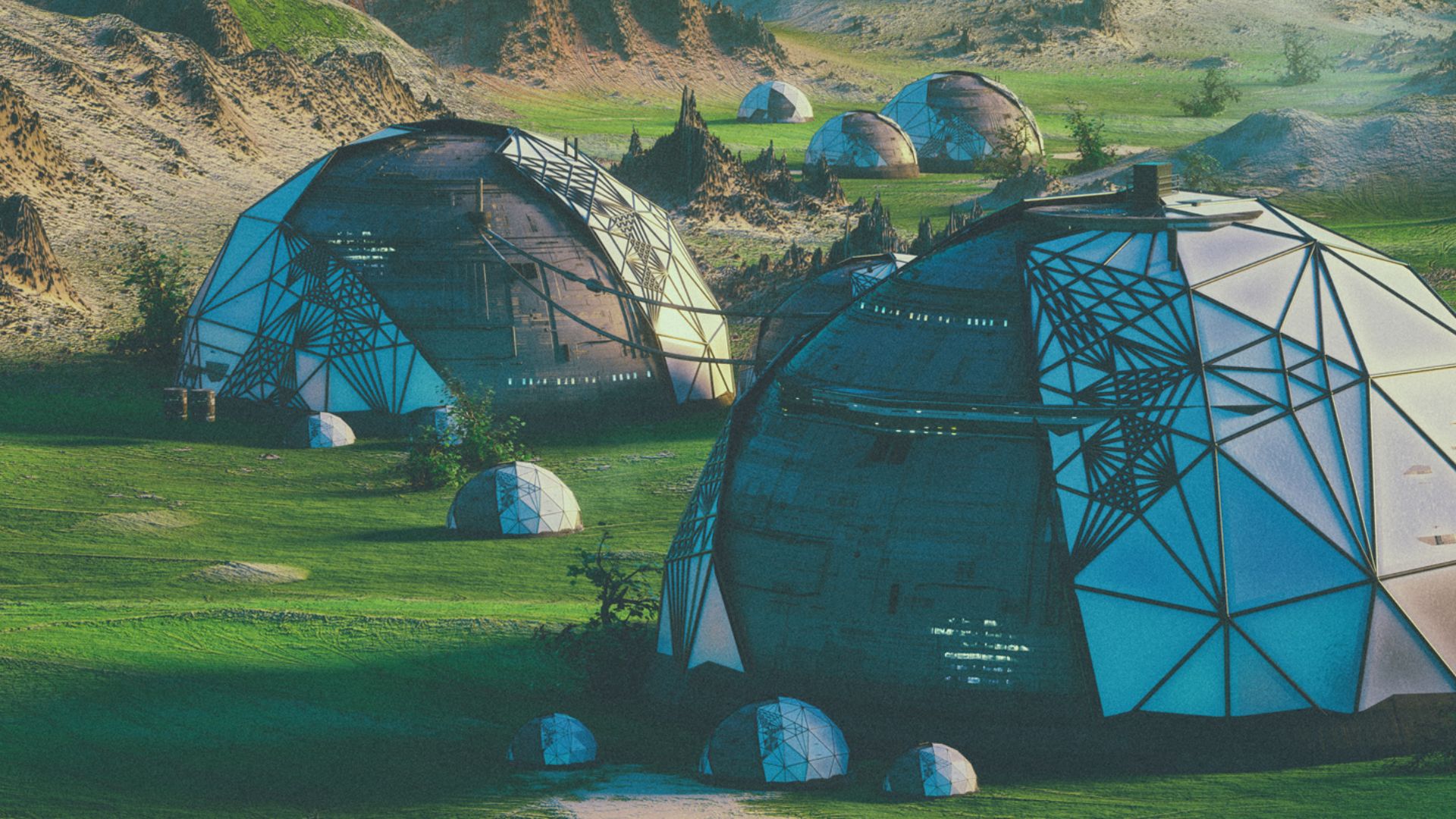 Dome shaped buildings in a green landscape with little vegetation.