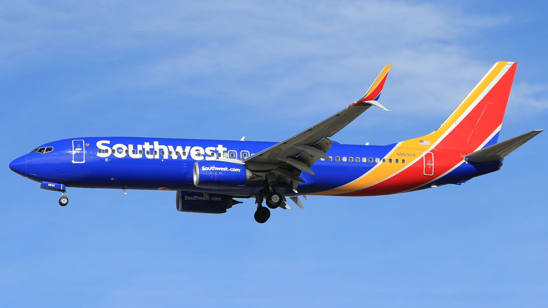 A vibrant Southwest Airlines airplane flying against a clear blue sky, showcasing its colorful livery.