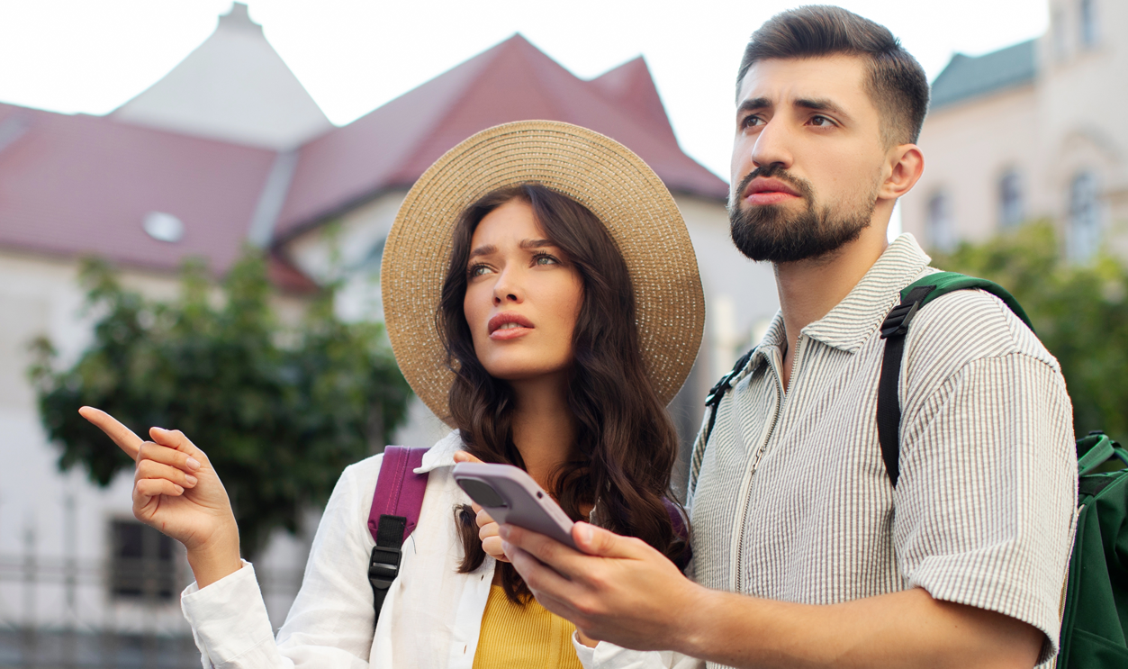 Worried couple using smartphone online maps at city center
