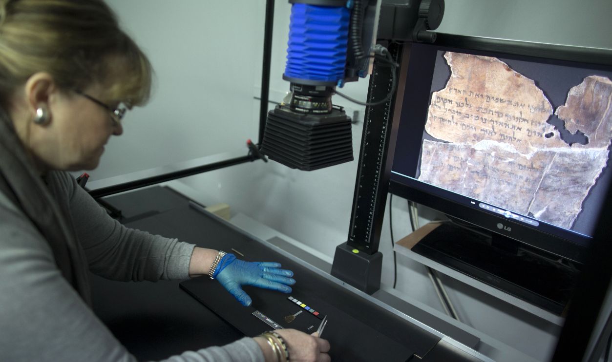 A conservation analyst from the Israeli Antiquities department photographs fragments of the 2000-year-old Dead Sea scrolls at a laboratory in Jerusalem before photographing them on December 18, 2012. The director-general of the Israel Antiquities Authority Shuka Dorfmann and Professor Yossi Matias, managing director of Google Israel, announced the publishing of the Dead Sea Scrolls online, initiated by the Israel Antiquities Authority and Google.