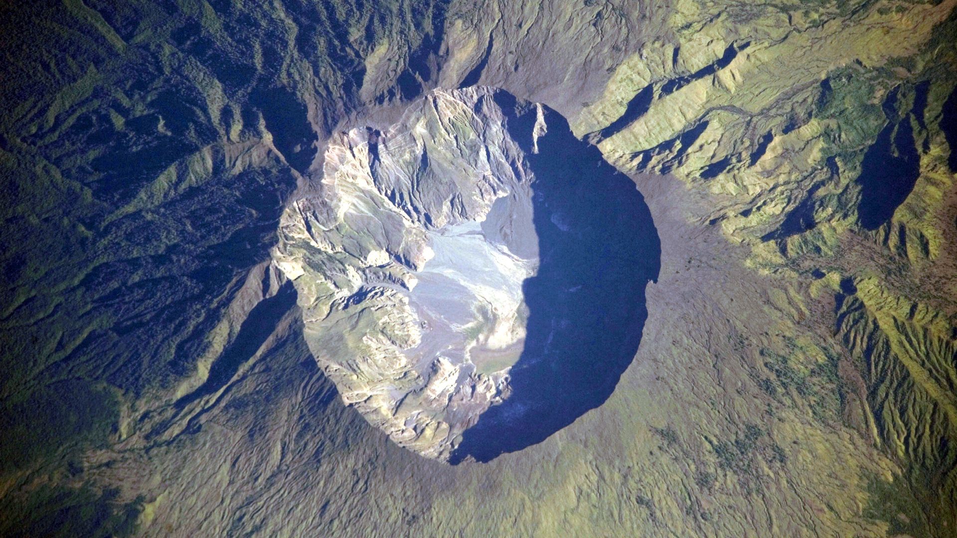 This detailed astronaut photograph depicts the summit caldera of the volcano. The huge caldera—6 kilometers in diameter and 1,100 meters deep—formed when Tambora’s estimated 4,000-meter-high peak was removed, and the magma chamber below emptied during the