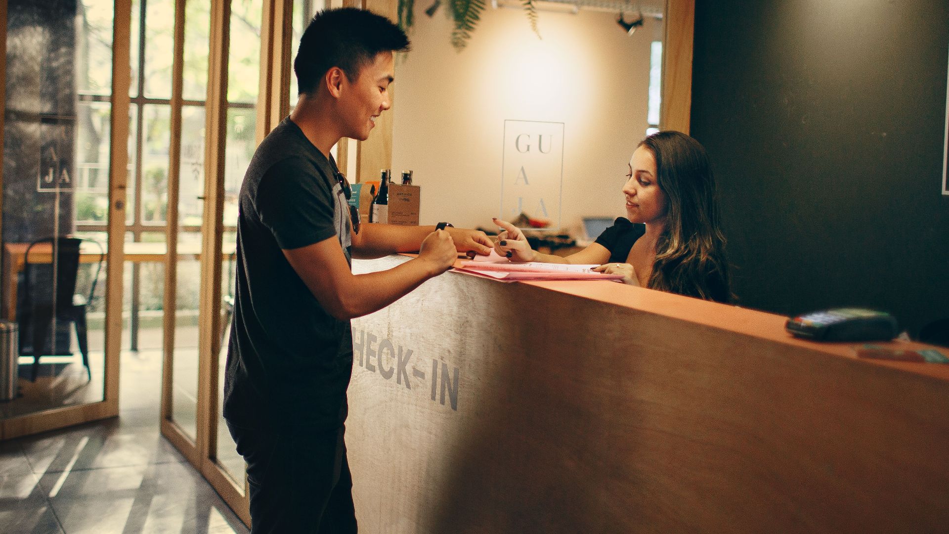A customer checks in at a hotel reception desk in Belo Horizonte, Brazil.