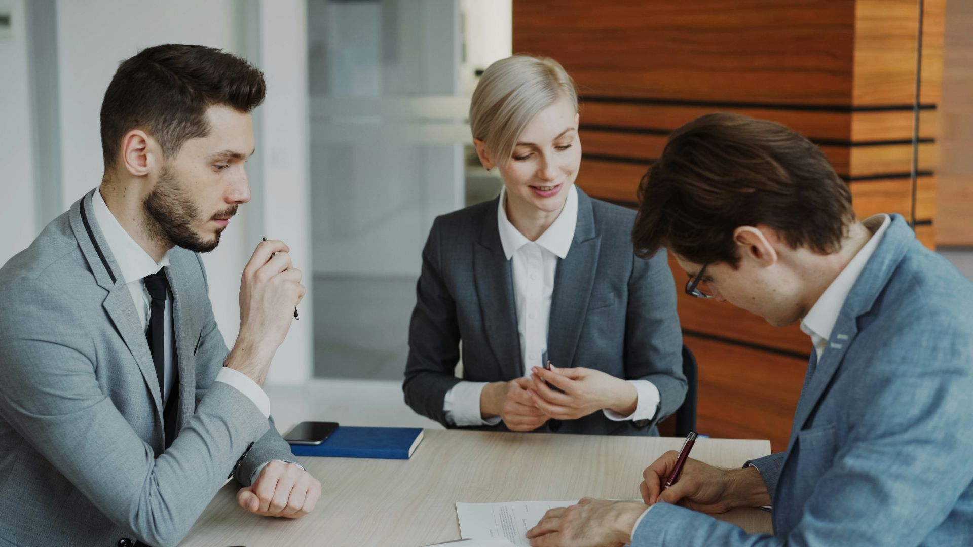 Business people signing a contract at a table
