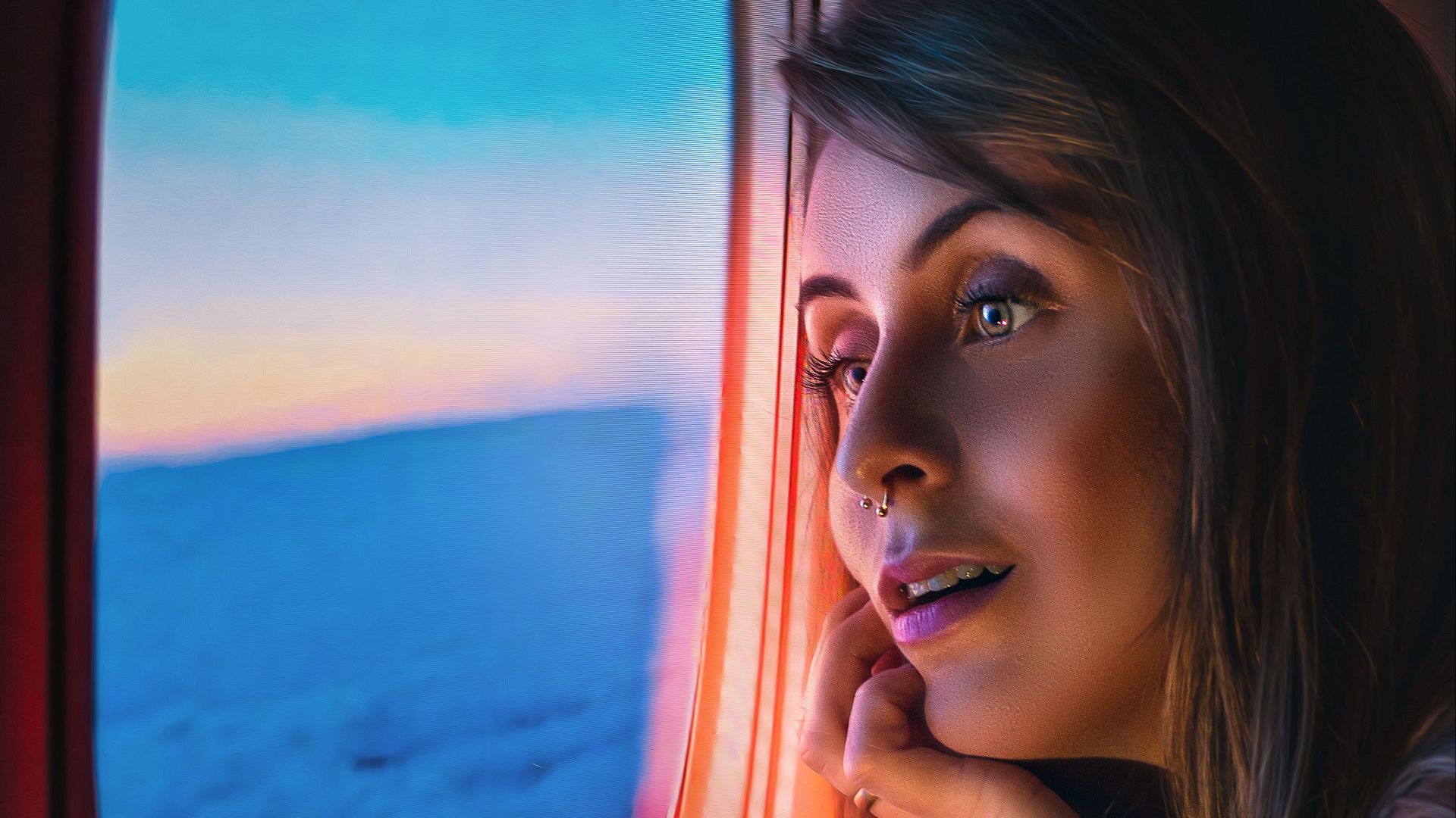 A woman gazes out an airplane window, admiring a scenic view of clouds and the sunset sky from above.