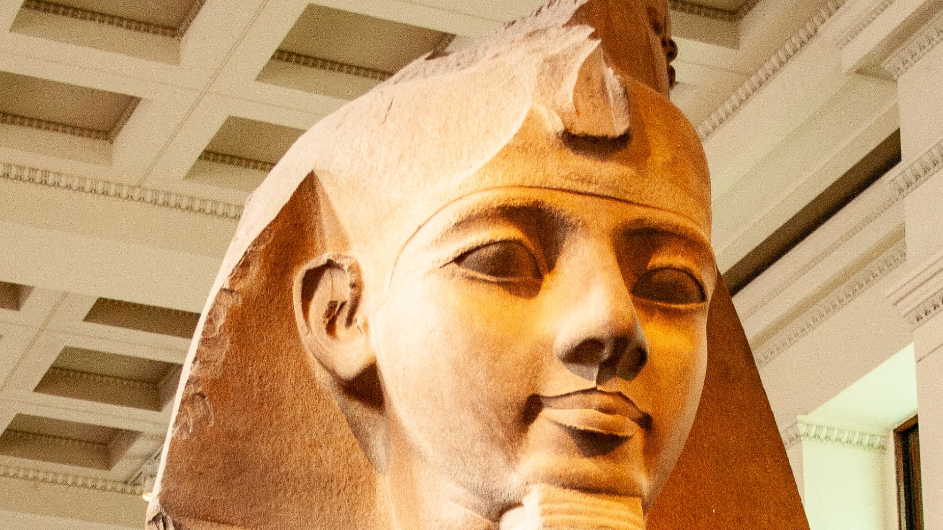 From the Ramesseum, western Thebes. One of a pair set up in the king's mortuary temple. The granite is naturally two colours, and was worked deliberately to draw a distinction between the head and body. The hole in the chest appeared before AD 1817, may h