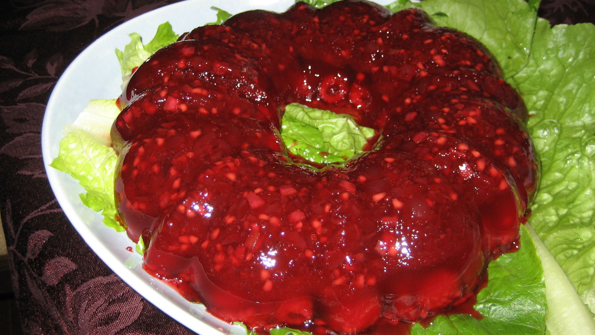 A cranberry jello salad made in a ring mold.