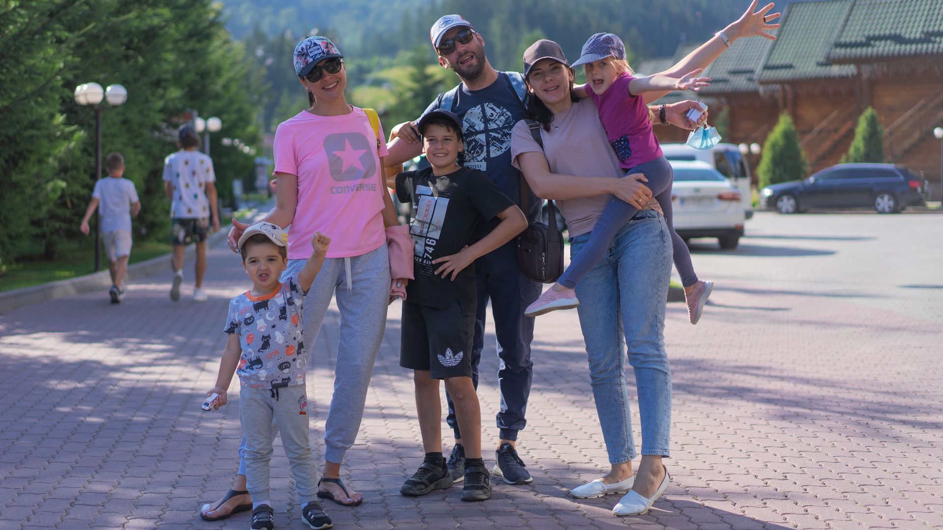 A joyful family of six spending quality time together in a scenic outdoor setting with mountains in the background.